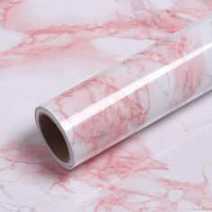 a roll of white and pink marble paper on a table with red veining around the edges