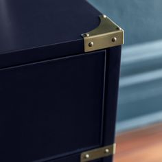 a close up view of a blue cabinet with brass handles