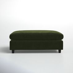 a green ottoman sitting on top of a white floor