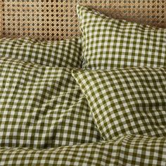 a bed with green and white gingham checkered sheets, pillows and pillow cases