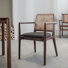 two chairs and a table in a room with wood logs on the floor next to them