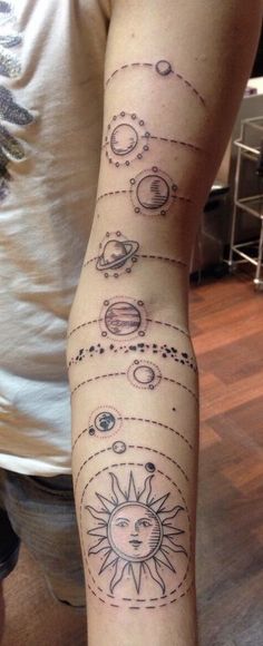 a person with a tattoo on their arm that shows the phases of planets and sun