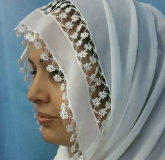 a woman wearing a white veil with flowers on it