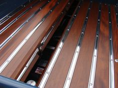 the inside of a vehicle with wooden flooring and metal railings on it's sides