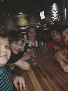 a group of people sitting around a wooden table