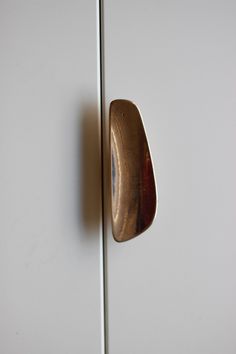 a close up of a door handle on a white cabinet