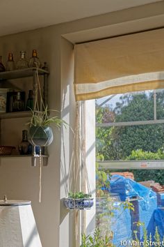 the window is open to let in some light and plants on the shelf below it