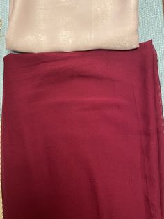 the bottom half of a red skirt with a white top on it, and another piece of clothing next to it