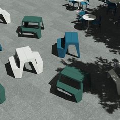 several different colored chairs and tables on the ground