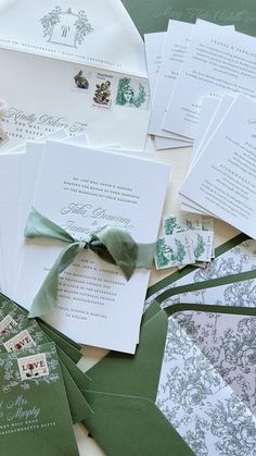 the wedding stationery is laid out on top of each other, including envelopes and cards