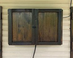 two wooden doors are attached to the side of a building with wires running through them