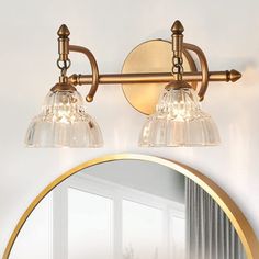 a bathroom light with two lights and a mirror on the wall above it in front of a window