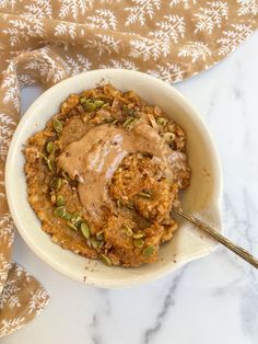 a white bowl filled with oatmeal and nuts on top of a table