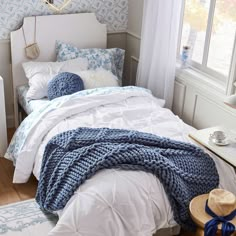 a bedroom with blue and white decor on the walls, bedding and rugs