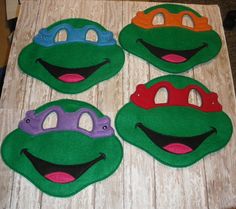 four teenaged turtles with masks on their faces sitting on a wooden table in front of a computer keyboard