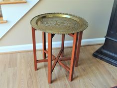 a small table sitting on top of a hard wood floor next to a stair case