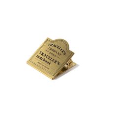 a gold colored business card holder on a white background with the words travelers'company printed on it