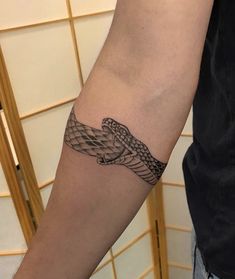 a man's arm with a snake tattoo on it