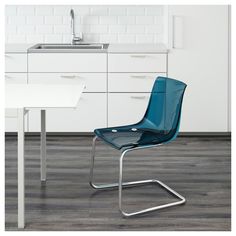 a blue chair sitting in front of a white counter top next to a kitchen sink