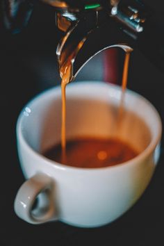 coffee being poured into a white cup