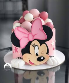 a minnie mouse cake with pink and white decorations