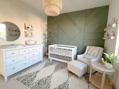 a baby's room with a white crib, dresser and chair in it