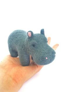 a hand holding a tiny stuffed animal hippo