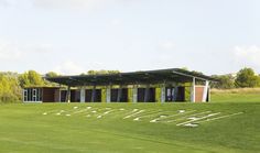 the word welcome written in white letters on a green golf course with trees in the background