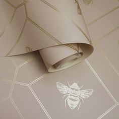 a wallpapered room with a bee on the wall and a lamp hanging from the ceiling