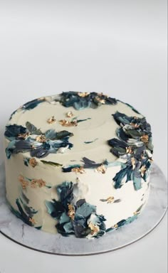 a white cake with blue and gold flowers on it