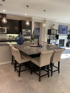 a large kitchen with an island in the middle and marble counter tops on both sides