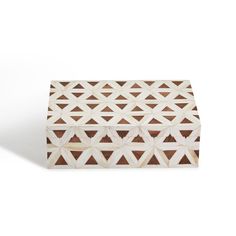 a wooden box with geometric designs on the front and sides, sitting on a white surface