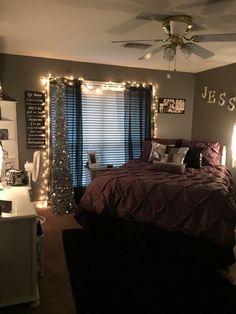 a bedroom decorated with christmas lights and purple bedding is pictured in this image from the front view