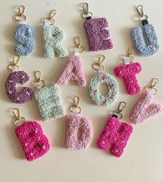 crocheted letters and numbers are arranged in the shape of magnets on a white surface