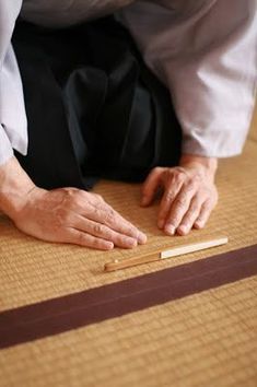 a person kneeling on the floor with two matches in front of them and one hand reaching for something