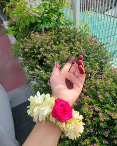 a woman's hand with flowers on it and a pink flower in the middle