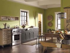 a kitchen with green walls and wooden floors