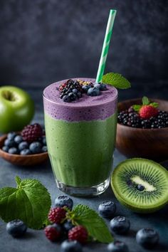 a green smoothie with berries and kiwi on the side next to other fruits