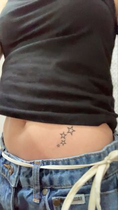 a woman's stomach with three stars tattooed on her lower body and the bottom part of her waist