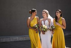 three women in yellow dresses standing next to each other