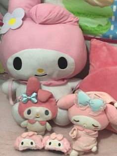 a hello kitty stuffed animal sitting next to two other stuffed animals