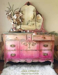 an old dresser has been painted pink with gold trimmings and flowers on top