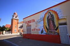 a mural on the side of a building with a clock tower in the background