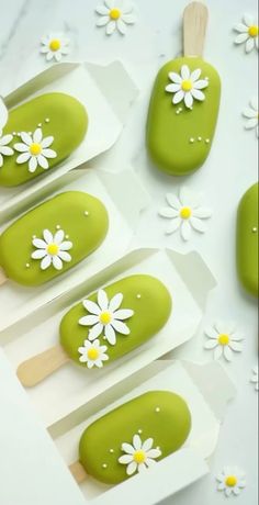 green and white nail polish with daisies on them, next to some popsicles