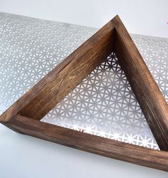 a wooden frame sitting on top of a white table with a flower pattern behind it