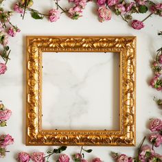 a gold frame surrounded by pink flowers on a white surface with space for the text