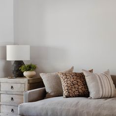 a couch with pillows and a lamp on top of it