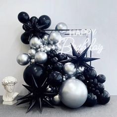 black and silver balloons are in front of a happy birthday sign with a busturine