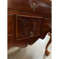 an antique wooden desk with ornate carvings on the top and drawer pulls down from it