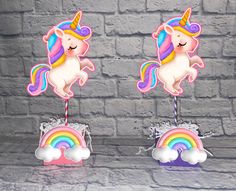 there are two unicorn cake toppers with rainbows and clouds on the bottom one